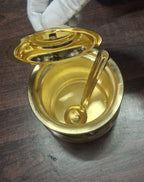 Traditional brass ghee pot with spoon